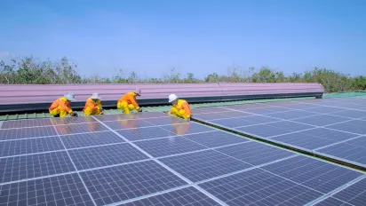 Technicians installing solar panels on a rooftop.