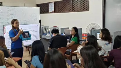 Lea Macababbad guides TESDA students during an AI classroom exercise.