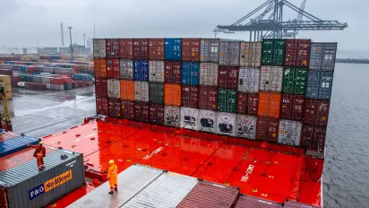 Dock workers and containers at a shipping terminal.