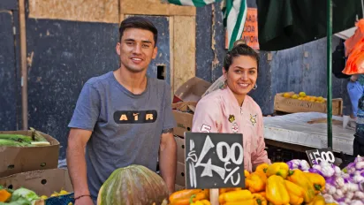 Jóvenes venden verduras en el mercado