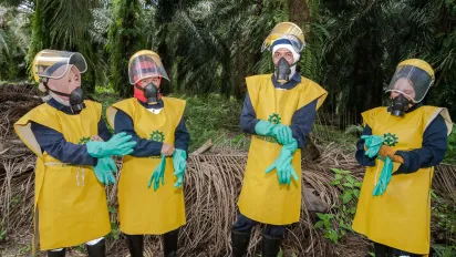 Indonesian female workers at palm oil plantation equipped with safety gears