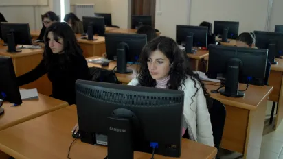 Group of young people in a classroom working on computers