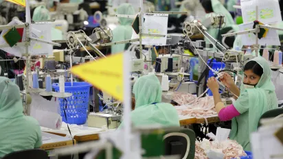 This is a photograph of a Bangladeshi woman in a ready-made garment factory in Bangladesh