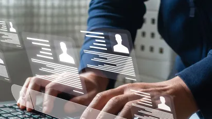 Hands typing on a laptop with a job search overlay on the screen