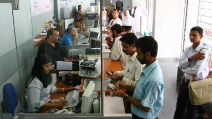 Workers at a local currency exchange and money transfer office provide service to customers.