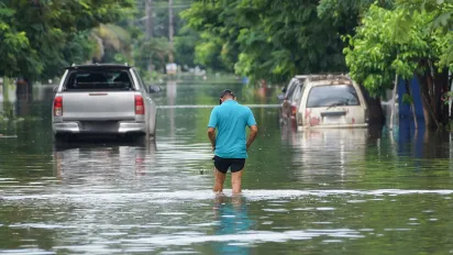 Man walking through flood waters