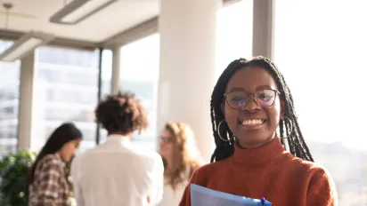 A young female student smiling with three classmates in the background