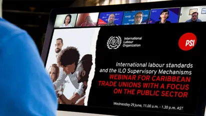 A man watching a virtaul seminar with partici[ants on the screen