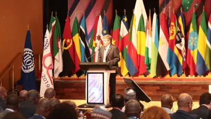 ILO Director-General Guy Ryder stands in front of a podium while speaking at the opening of the 14th ILO African Regional Meeting in Abidjan, Ivory Coast.
