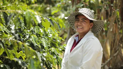 Mujer caficultora en cafetal del departamento del Huila, Colombia 