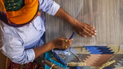 Indian man weaving durries