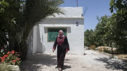 Ghada Al-Qudah walks in front the headquarters of the all-female cooperative she leads in Ajloun in northern Jordan.