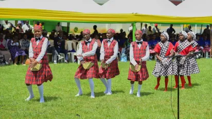 Children in red uniform do a dance performance during the world day against child labour commemoration ceremony