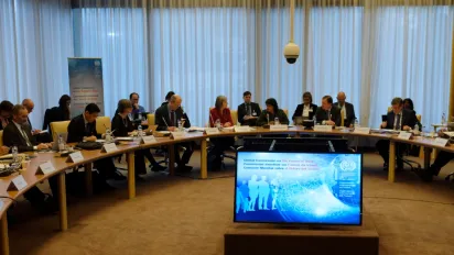 Business professionals seated at a table in a conference room, having a discussion.