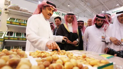 A local produce seller displays his dates to clients at an exhibition.