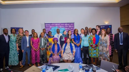 Staff of ACCEL Africa pose with a banner of ILO logos and Africa at the back