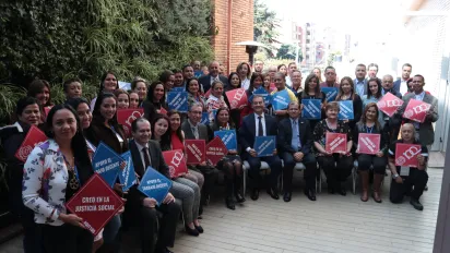 foto grupal de inspectores del trabajo de Colombia sosteniendo letreros alusivos a la conmemoraicón de los 100 años de la OIT como "apoyo el trabajo decente" y "creo en la justicia social"