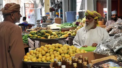 A man in Oman speaks with a street vendor