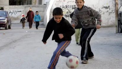 Two Palestanian boys play football in streets of Amman, Jordan