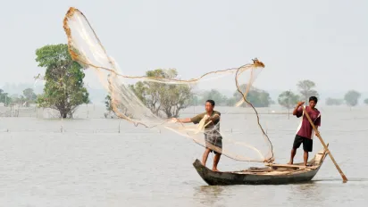 Fishermen throwing a net from their boat 