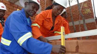 Man and woman building a house made of bricks 