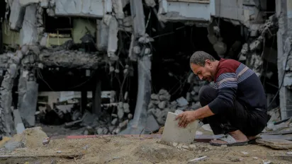 Abu Mohammad, inspects stones from his destroyed house in Sheikh Zayed City, north of the Gaza Strip.