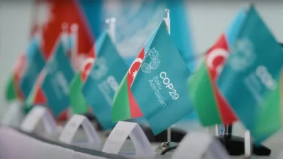 Row of desk flags with COP29 logo and Azerbaijan flags