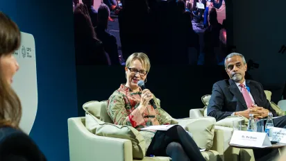 Men and women sitting on chairs holding microphones