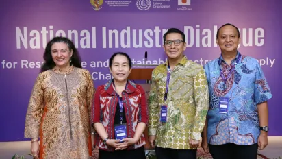 Four representatives of the ILO, trade union, Coordinating Ministry for Economic Affairs and Ministry of Manpower standing on the stage.