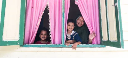 a mother with 2 kids looking out from a big window