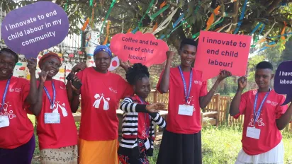 Young people pose for a picture holding messages against child labour
