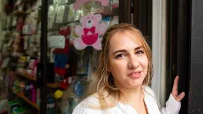 woman wearing a white shirt standing outside a shop