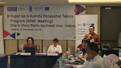 An ongoing meeting with two speakers sitting on the front and the participant sitting on the side.