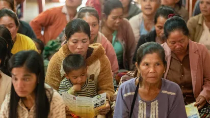 Women, men and children sit together. 