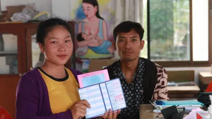 A pregnant woman holds documents. 