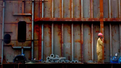 a male shipyard worker communicating through a handy talkie