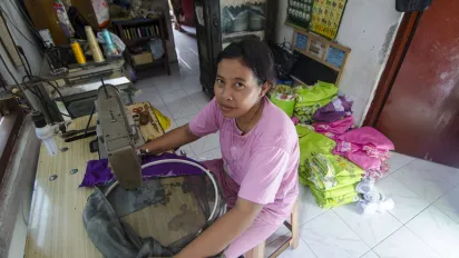 a female homeworker sewing made-to-order clothes