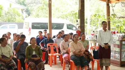 Women and men sitting on chairs. 