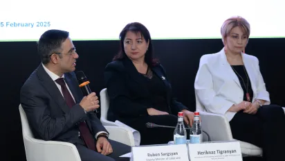 3 members of the panel sit in front of the screen with mics in hand during the high-level discussion on public works programmes (PWP) on 5 February 2025 in Armenia