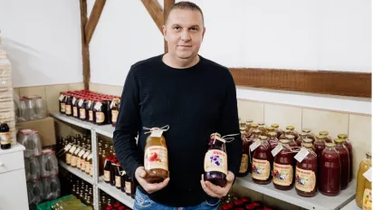 Almir holding two bottles of his homemade natural juices
