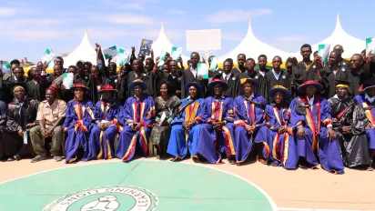 young men and women at the graduation ceremony in Kenya wearing the graduate trench sets