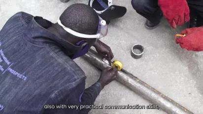 A welding student preparing metal before welding
