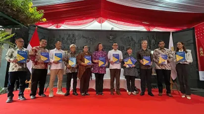 A group of people standing on the stage holding a publication.