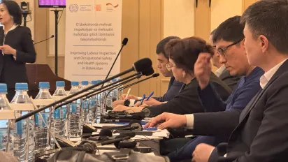 A group of people sitting at a table with microphones