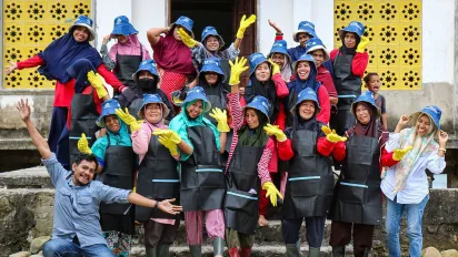 A group photo of women and men wearing colourful hats and outfits.