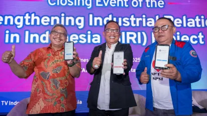 Three persons standing on the stage showing off their smartphones.
