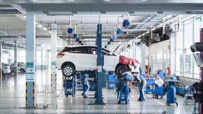 Workers are assembling a car. 