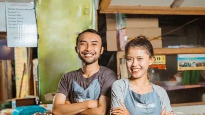 hero-image-smiling-asian-man-woman-wearing-apron-standing-traditional-stall