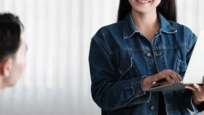 young asian woman smiling and holding laptop