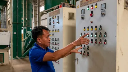 Man operating an electric panel in a factory